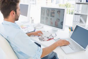 Side,View,Of,A,Male,Photo,Editor,Working,On,Computer